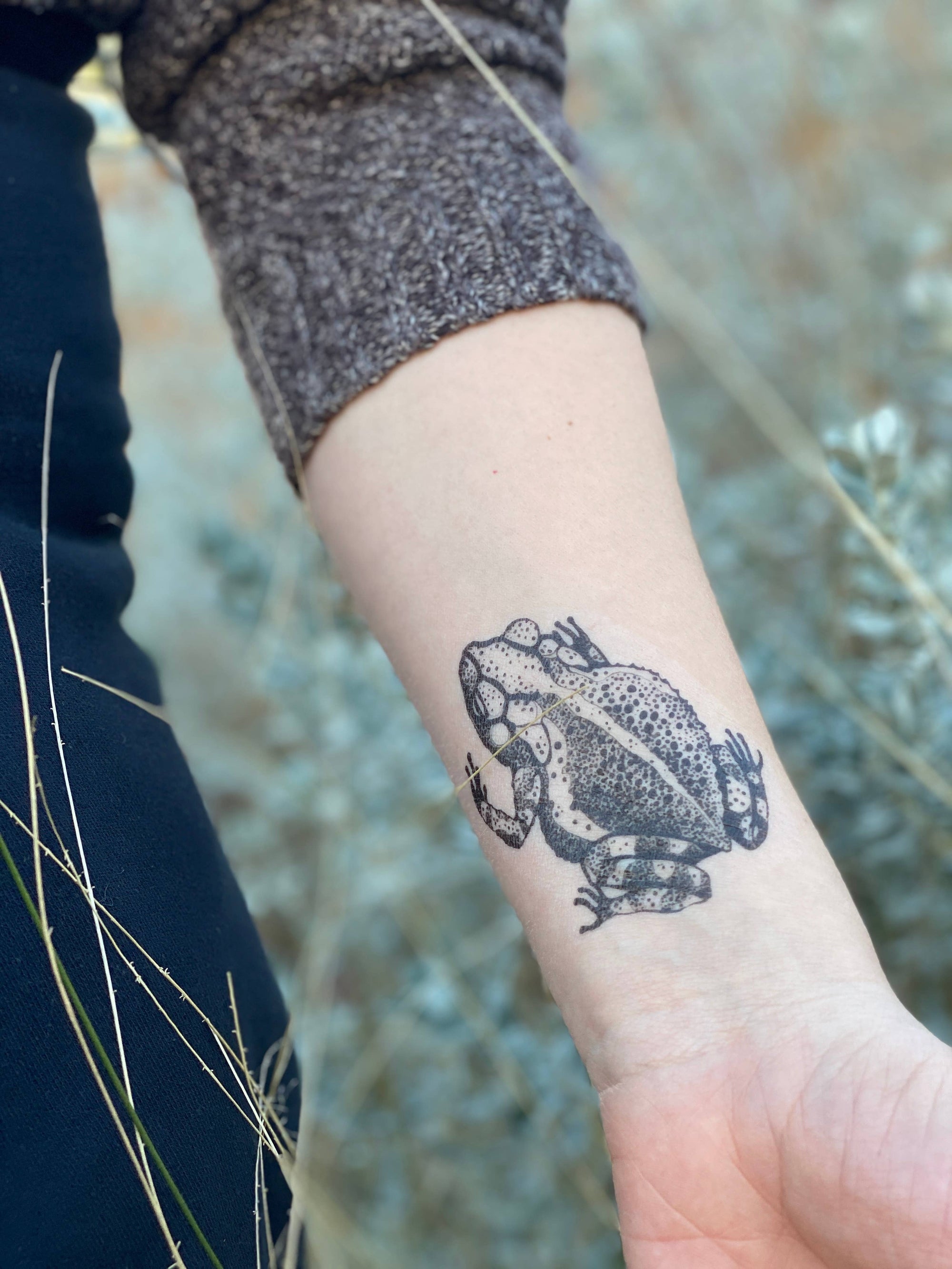 Toad temporary tattoo. Hand-drawn in black lines and stippling. Specifically, a gulf coast toad, these spring and summer-loving creatures are beloved garden friends to many who can see the delight in their presence.
Choose 1-Packs or 2-Packs!
Lasts 2-5