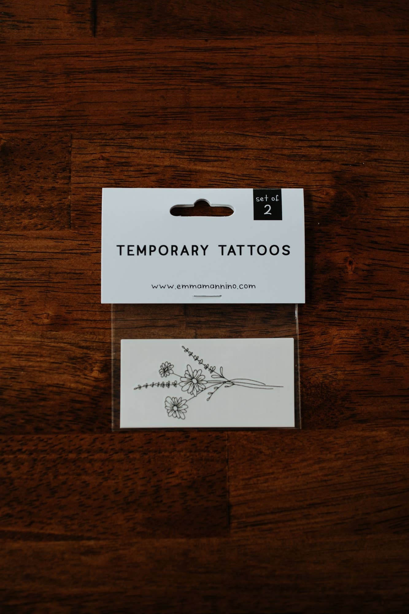 Featuring thoughtfully hand drawn daisies, this temporary tattoo makes a thoughtful small gift to anyone taking on a new venture or a pain-free way to try out a tattoo!

DETAILS:
Set of two temporary tattoos
Dimensions: 3" x 1.5"
Safe, non-toxic, and FDA 