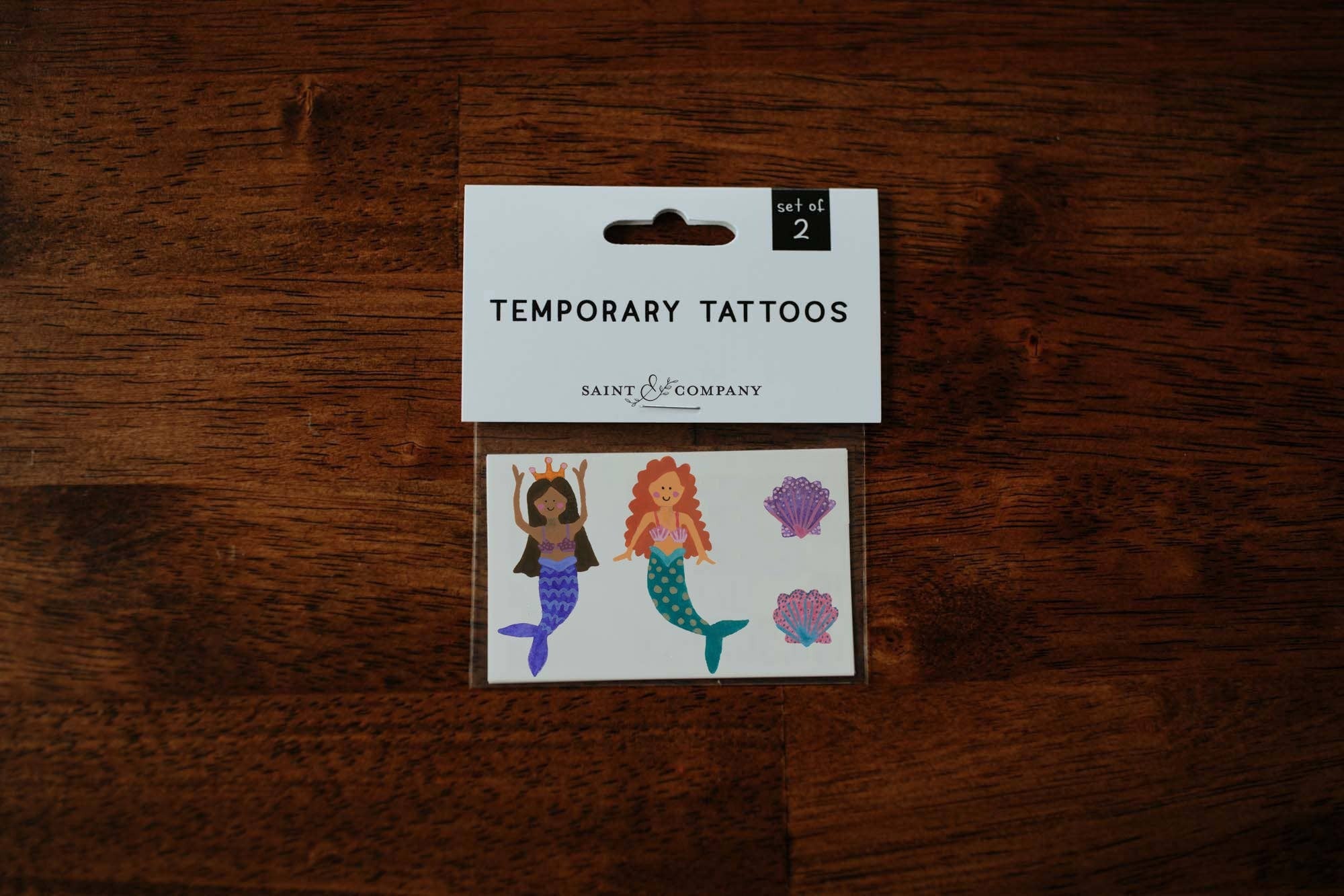 Featuring two mermaids and two seashells, this tattoo set is perfect for any mermaid lover!

Set of 2 temporary tattoos

Size of sheet: 3 inch x 2 inch

Application Directions: Place the tattoo face down on skin. Apply even pressure to the tattoo paper ba