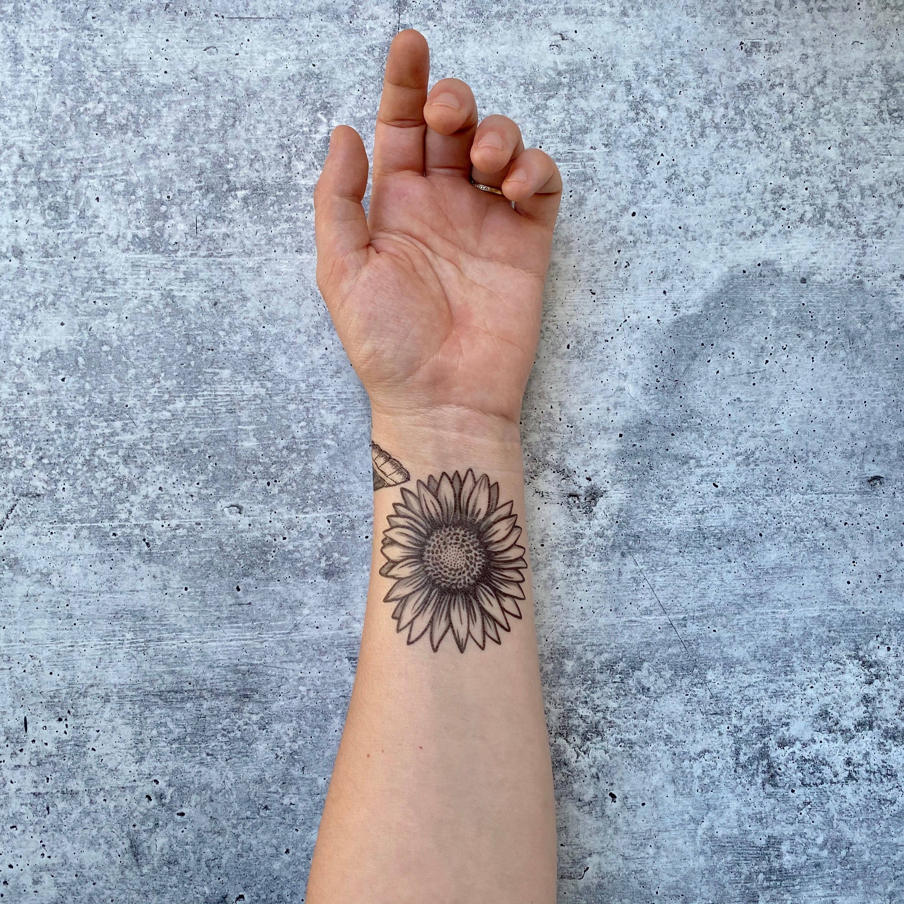 Sunflower temporary tattoo 2 pack. A full-bloom sunflower with full-bloom summer vibes. This design is about 3" wide.

All tats now come in 2 Packs!
Lasts 2-5 days • Water-resistant • Comfortable • Skin Safe
All original designs by Allison Wilcoxen in Aus