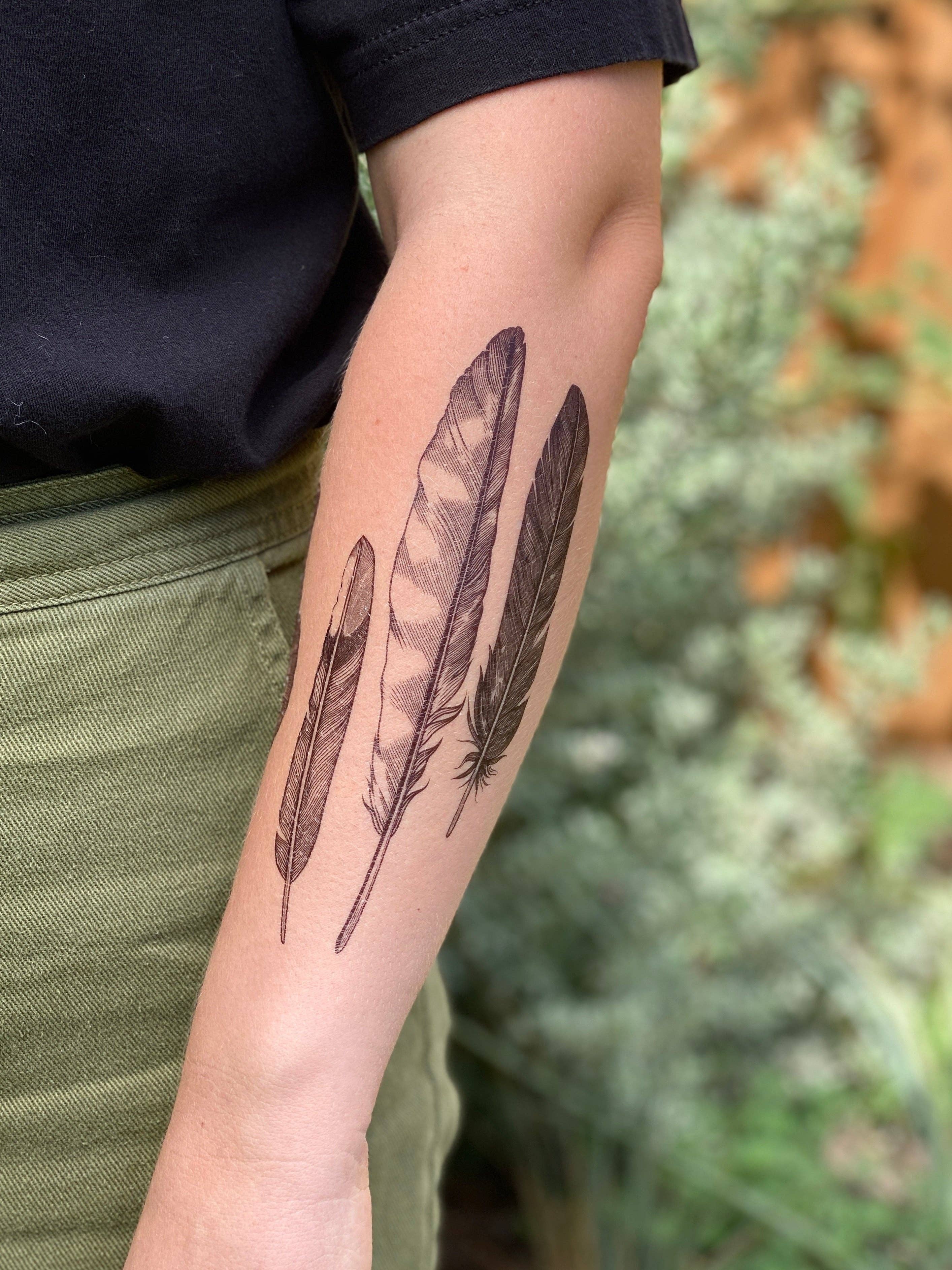 Feather Finds temporary tattoo 2 pack! Three different feather temporary tattoos can be cut out or worn together as a collection. Feathers represented are a small mockingbird feather, a long hawk feather, and a black mystery feather, perhaps a raven, crow