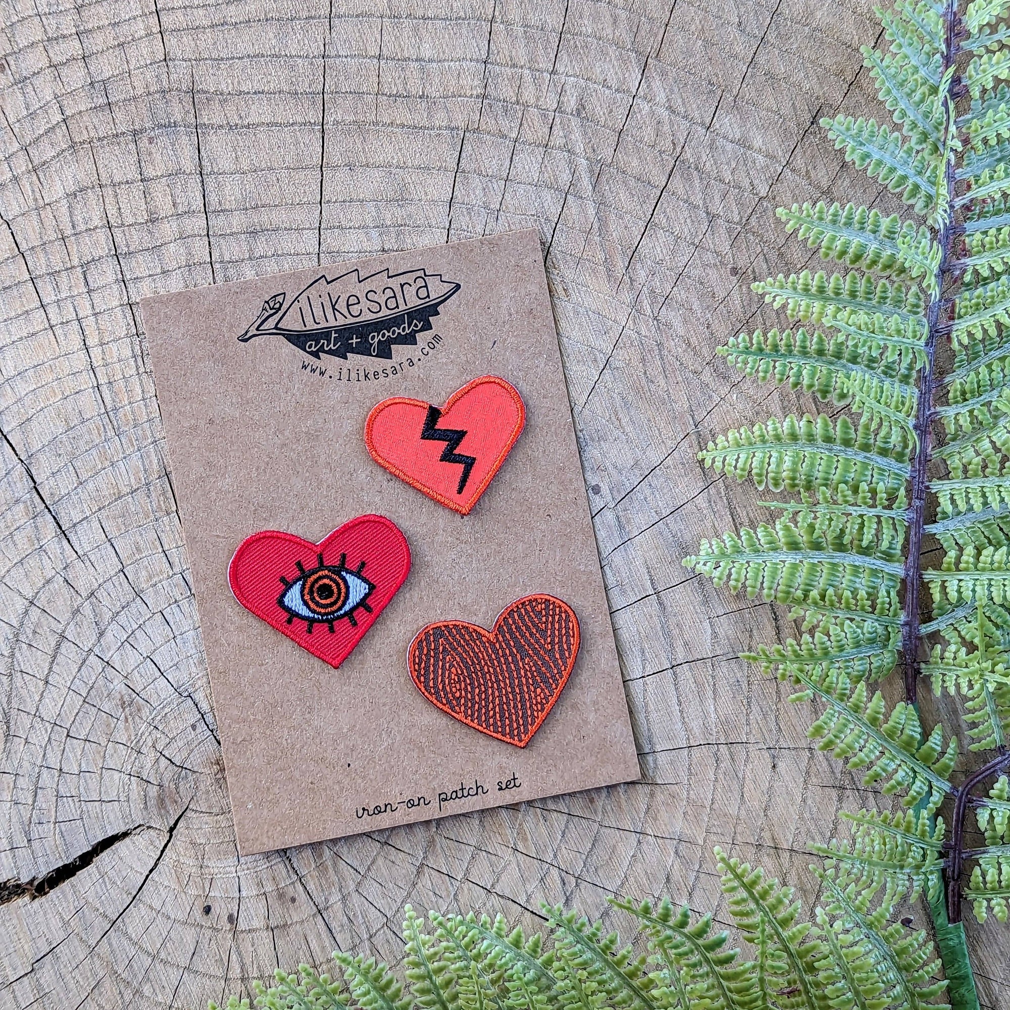 3 heart patches to adorn wherever you need some love! Featuring the all-seeing heart, a broken heart, and woodgrain heart . Based on illustrations by ilikesara / Sara Schalliol-Hodge.

Each heart is about 1"-1.25" tall and 1.5" wide, which we think is the
