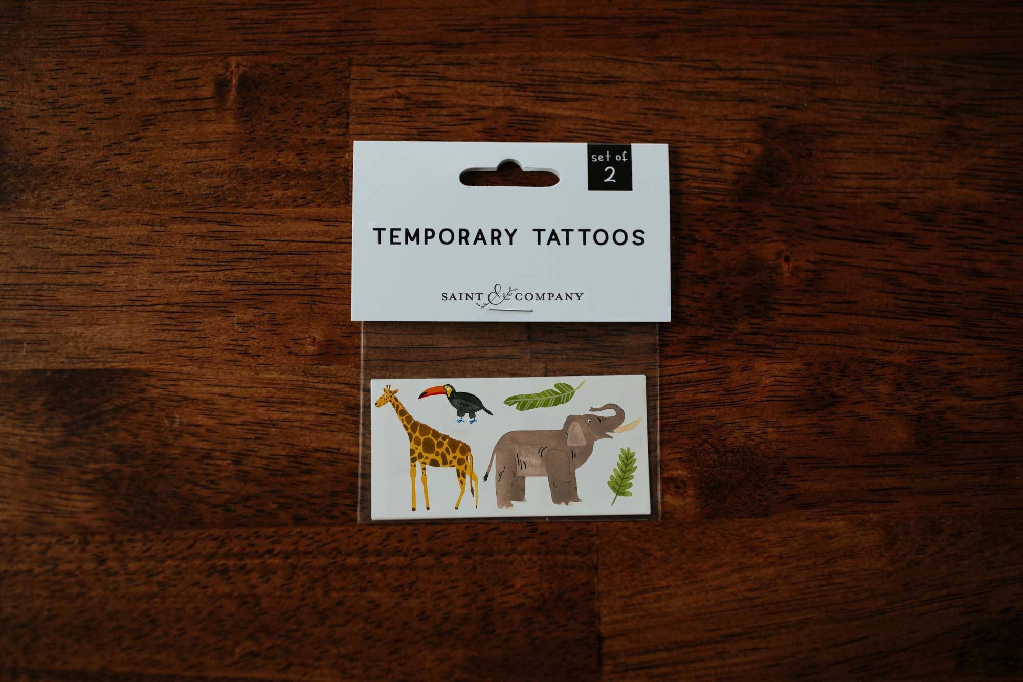 Get ready to embark on a wild adventure with our jungle tattoos! These bold and vibrant temporary tattoos are sure to bring some fun to your day. This originally hand-painted tattoo sheet features an elephant, a giraffe, a toucan, and colorful jungle leav